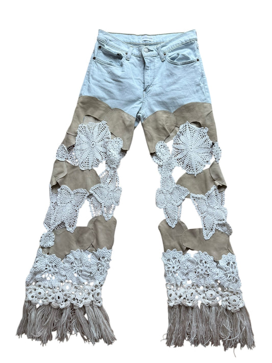 jeans with lace, leather and fringe details on a white background