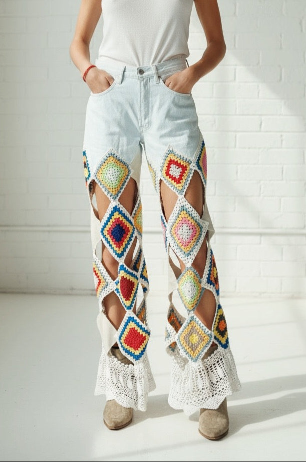 Woman wearing colorful crochet and leather pants and a white tank top in a bright room.