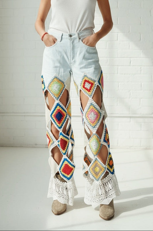 Woman wearing colorful crochet and leather pants and a white tank top in a bright room.